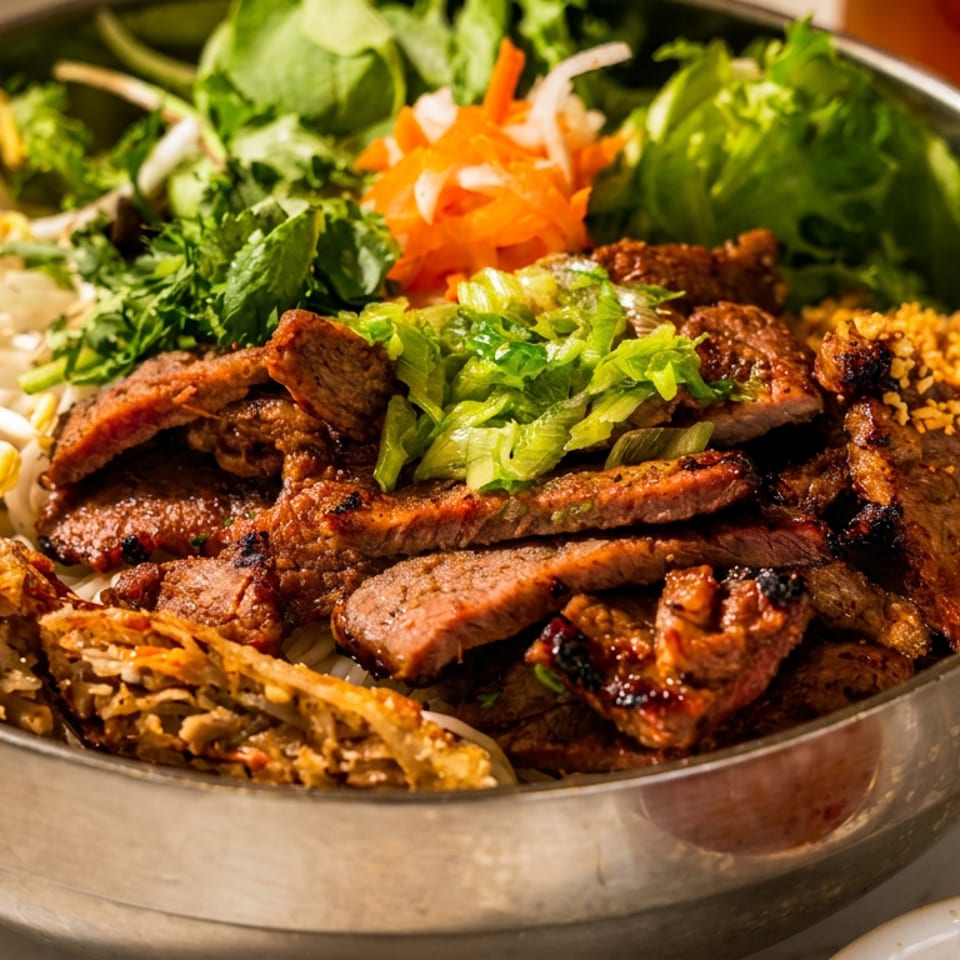 Bowl of grilled meat with herbs, lettuce, pickled vegetables, bean sprouts, crispy spring rolls, and crushed peanuts.